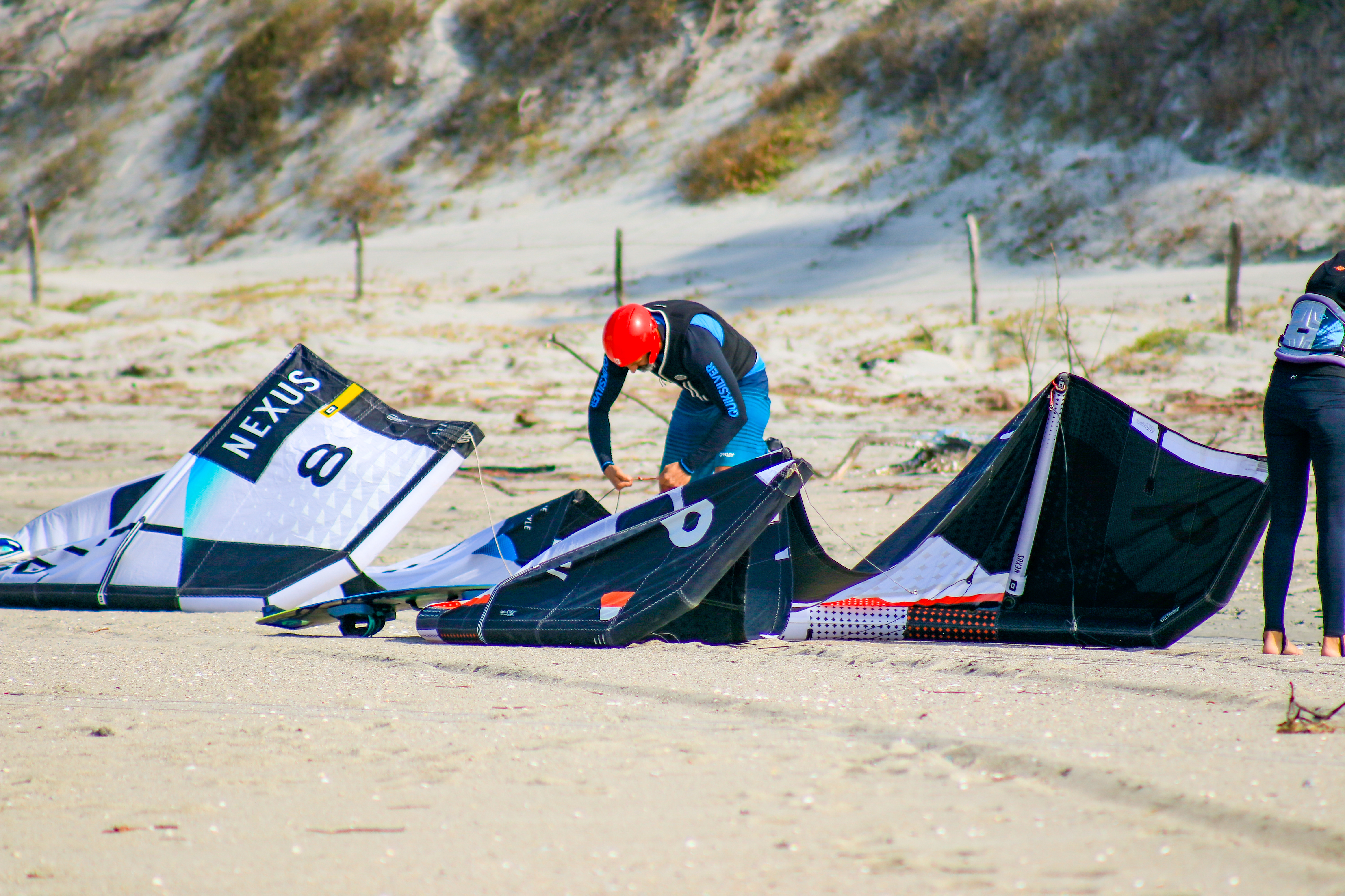 A kitesurfer riding a wave at sunset